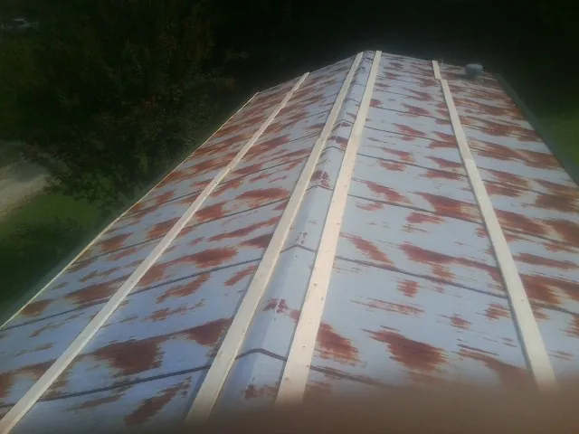Rusted metal roof panels with new wood purlins before replacement — Storm Damage Roof Repair in Nakina by Roofing Brothers