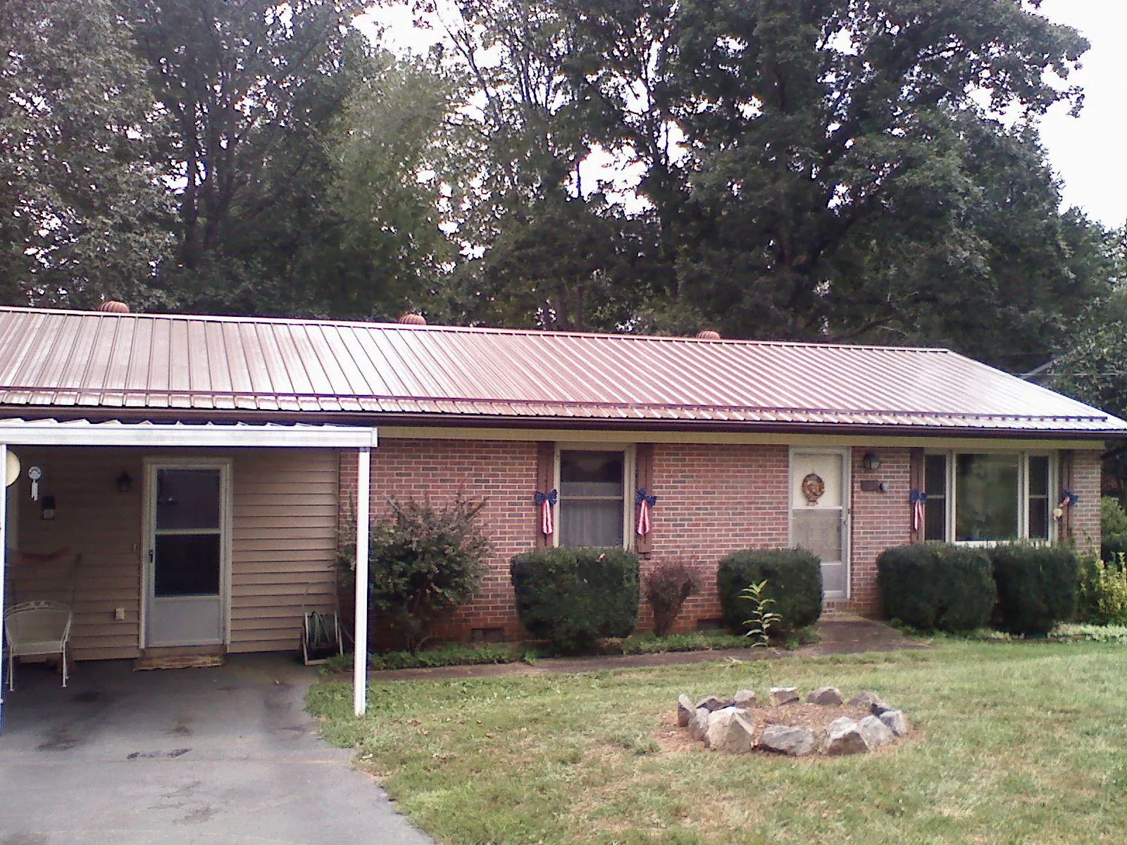 Bronze metal roof and carport on a brick ranch home — Roof Repair work by our crew in Nakina