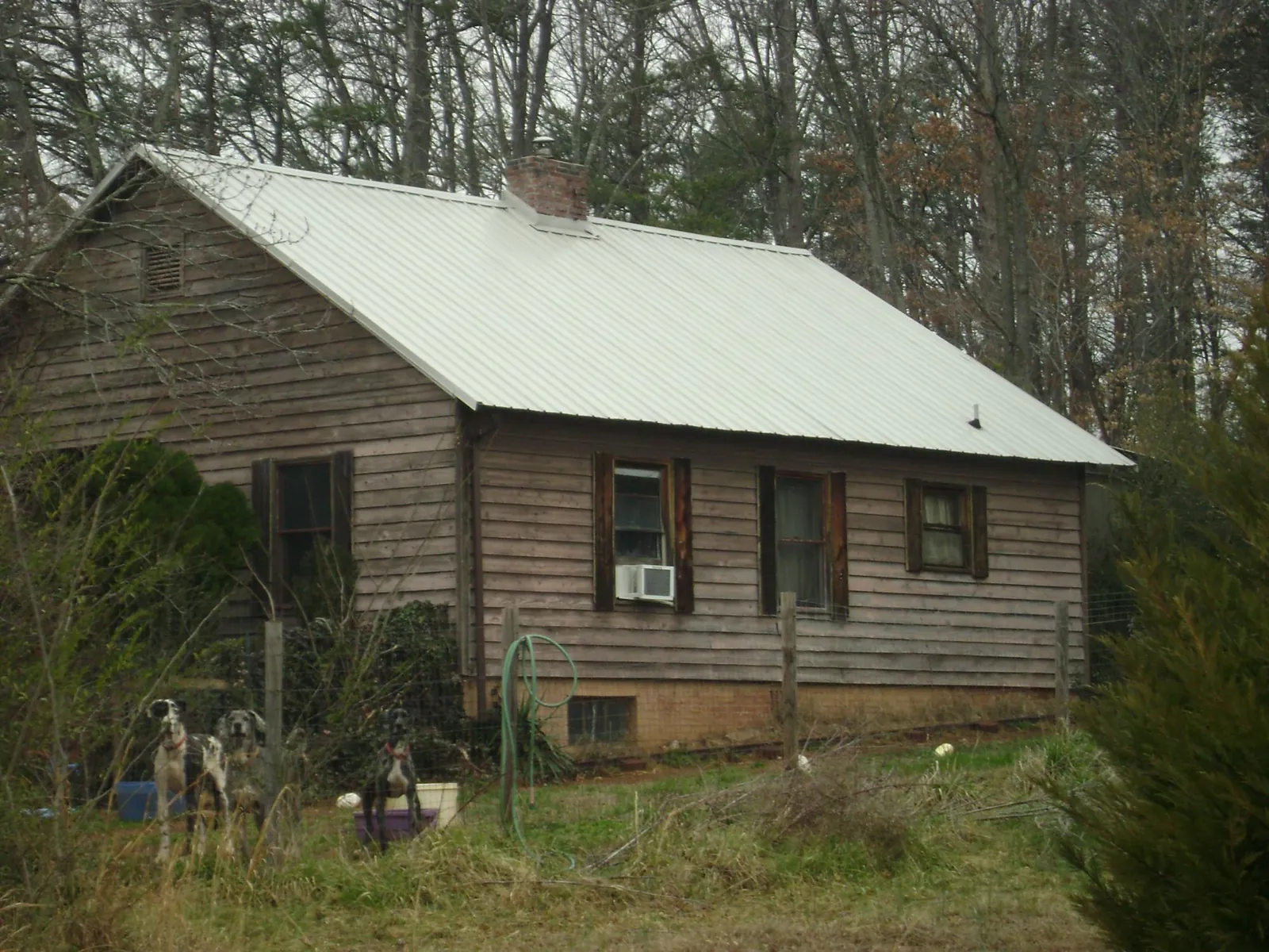 White metal roof on an old wood sided farmhouse, from a Metal Roof Installation job in Nakina